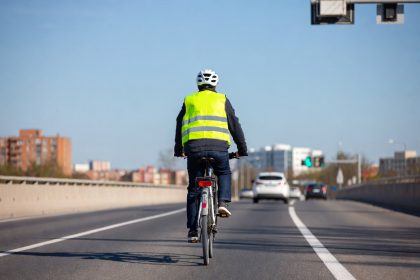 Pesepeda perkotaan dengan perlengkapan lengkap melintas di jalan raya