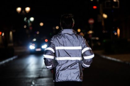 Pelari Malam dengan Jaket Reflektif di Jalanan Gelap
