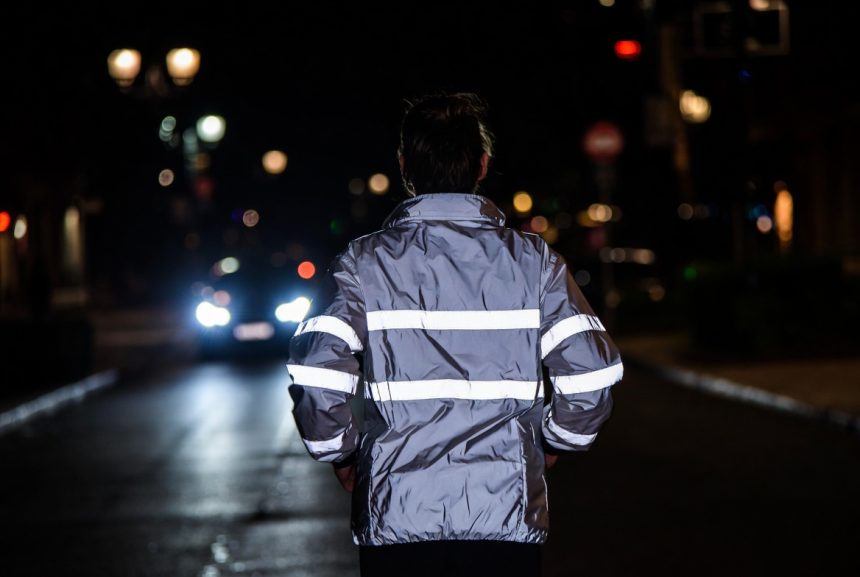 Pelari Malam dengan Jaket Reflektif di Jalanan Gelap