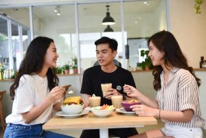 Anak muda Indonesia menikmati makanan nabati di kafe