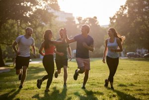 sekelompok teman lari pagi bersama di taman kota saling tertawa dan memberi semangat